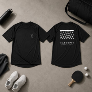 Schwarze High-Tech Tischtennis Bekleidung Frankfurt von AERONOVA im Flatlay-Setup auf Betonboden. Sichtbar sind die Vorderseite mit rautenf&ouml;rmigem &sbquo;FRA&lsquo;-Logo und die R&uuml;ckseite mit dem &sbquo;Mainspin Bembel&lsquo; Netzdesign, das an ein Frankfurter Geripptes Apfelweinglas erinnert.